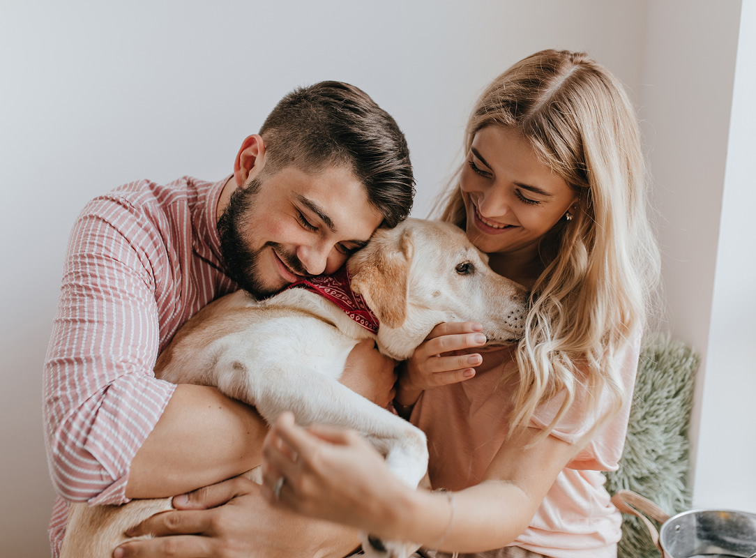 Husband wife play with dog