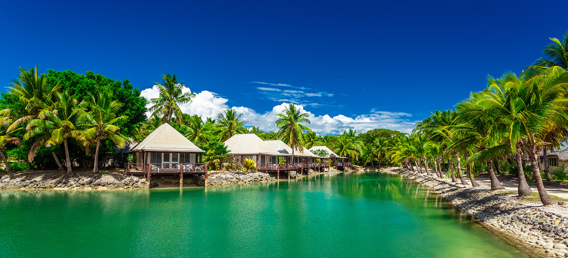 Tropical beach with coconut palm trees and clear lagoon Fiji islands